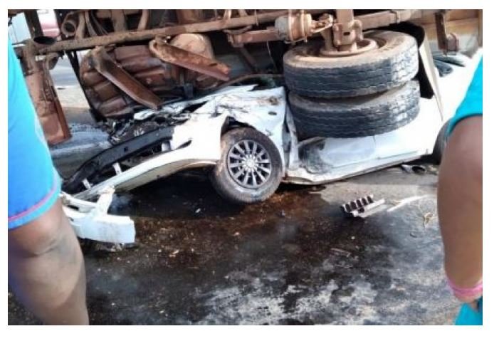 Carreta tomba sobre carro e deixa 4 pessoas presas às ferragens