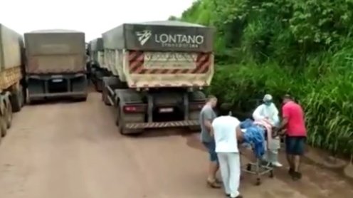 Paciente com cilindro de oxigênio em maca é levado pela BR-163