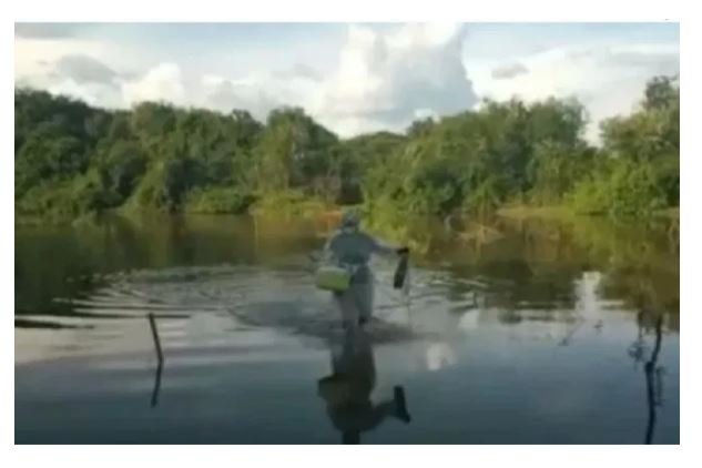 Enfermeira atravessa rio andando para vacinar idosa