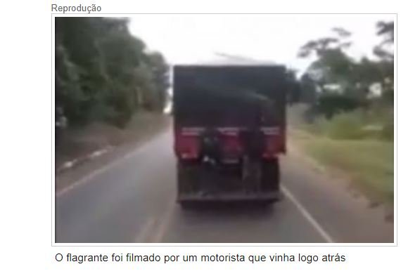 Dupla se arrisca no parachoque de caminhão em rodovia