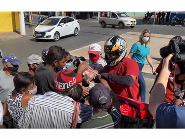 Motoboy distribui pacotes de frangos para pessoas na "fila dos ossinhos"; veja vídeo