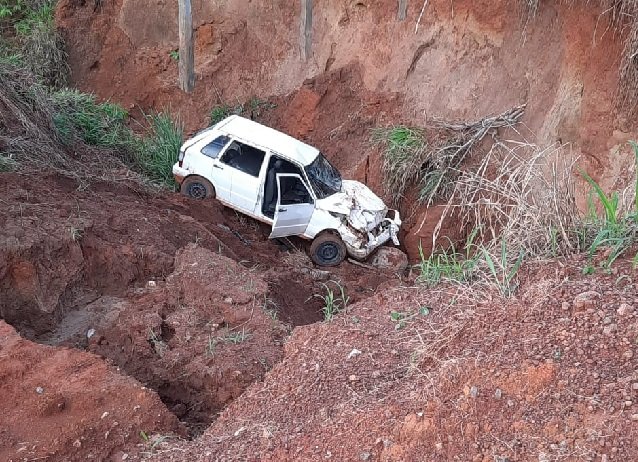 Carro cai em cratera na margem da estrada, moradora registra o episódio e divulga em redes sociais.