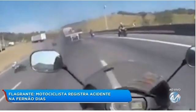 Motociclista cai debaixo de carreta e sai andando após acidente. (Vídeo)