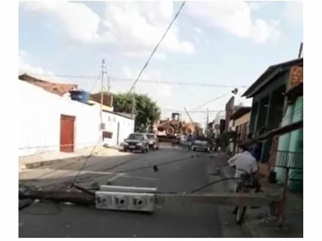 Caminhão carregado com trator bate em fiação e derruba sete postes em Cuiabá