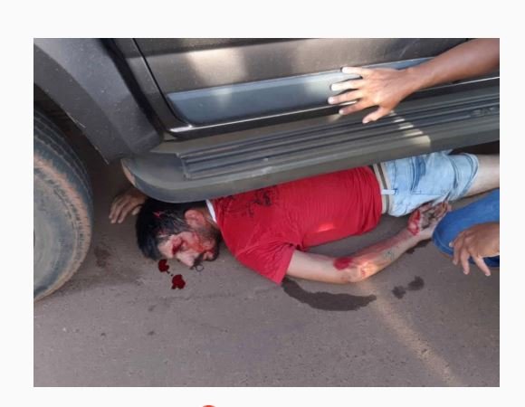 Homem cai da garupa de uma moto, vai parar embaixo de uma caminhonete e escapa da morte por milagre.
